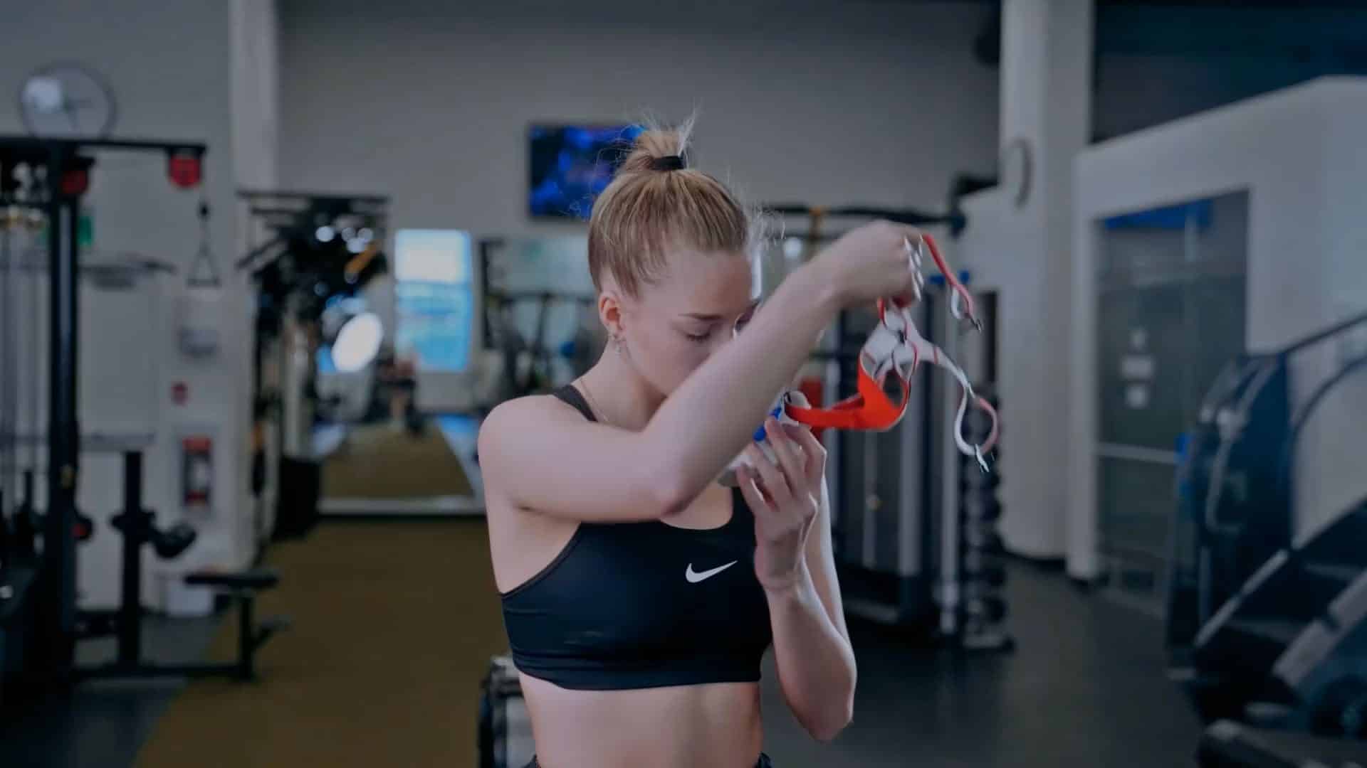 woman shown putting on a v02 master analyzer in a gym setting preparing to track training metrics.