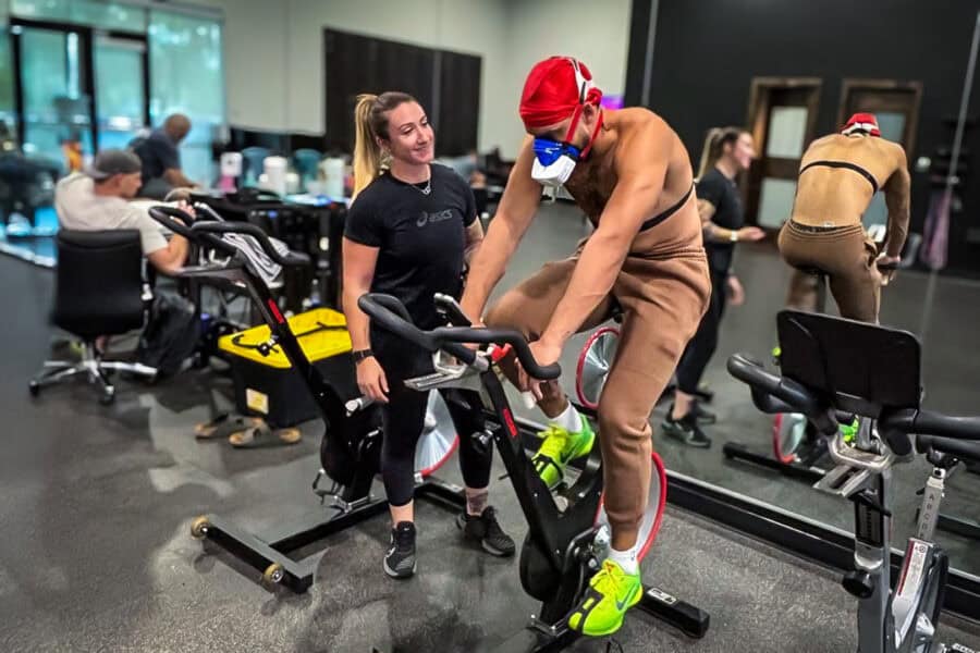 Athlete on a stationary bike wearing a VO2 Master mask during vo2 testing for athlete in a training facility