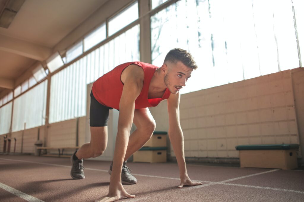 Male runner getting ready to sprint indoors
