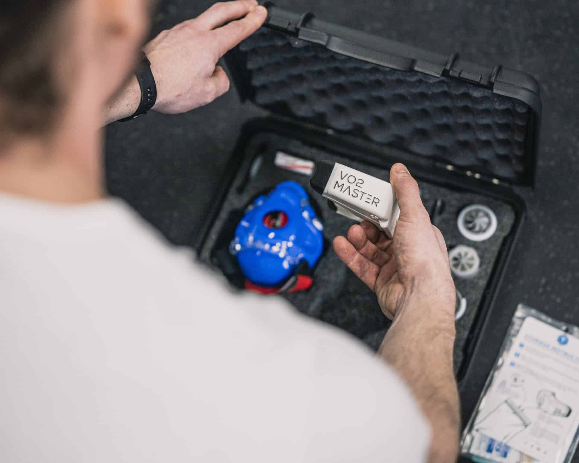 a trainer looking at the various components of the vo2 master portable metabolic analyzer in its protective carrying case