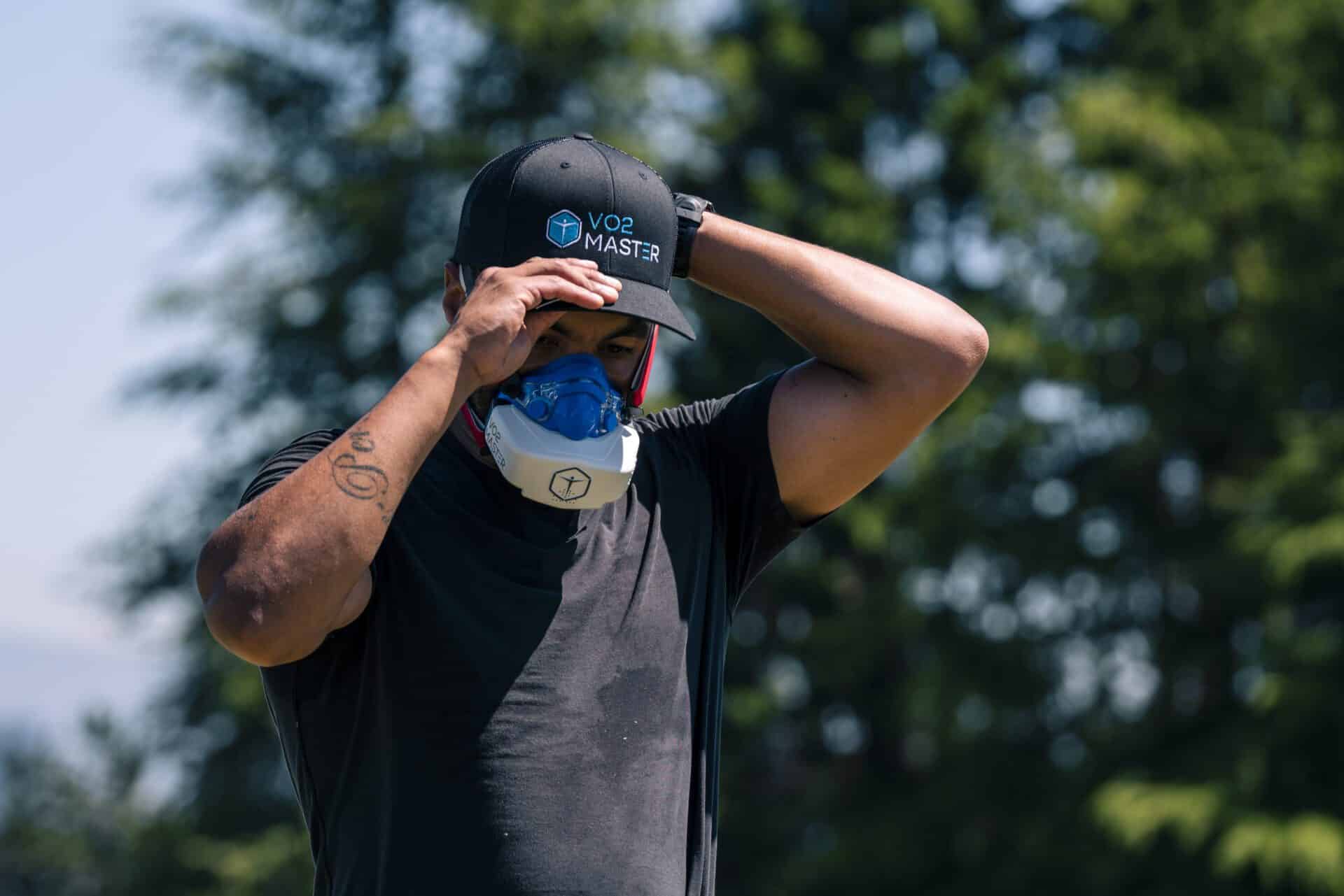 man putting on VO2 Master hat, wearing the analyzer outdoors