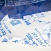Up close shot of multiple desiccant pouches and bag in the background