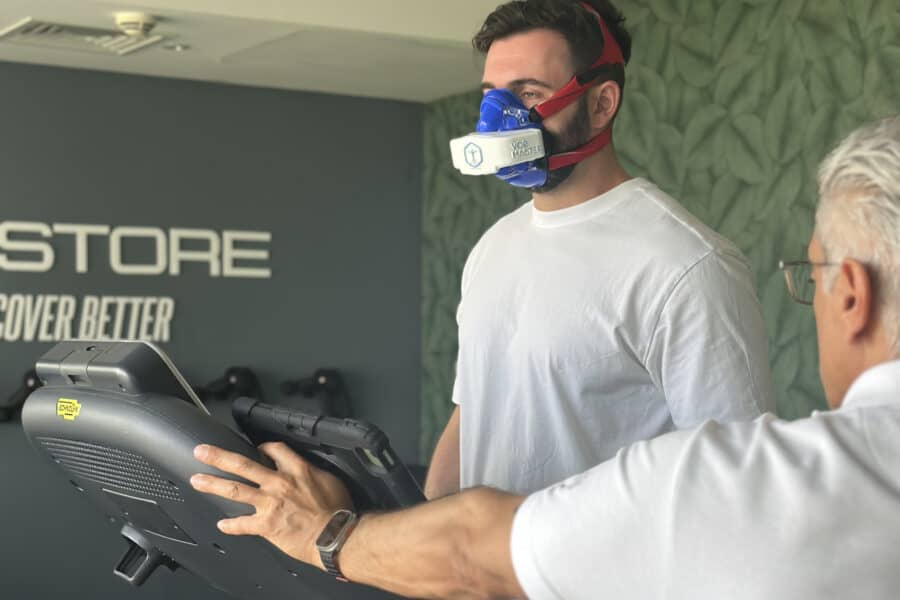 Athlete performing VO2 max test using VO2 Master Analyzer at Restore Fitness Dubai, guided by coach during metabolic performance assessment.