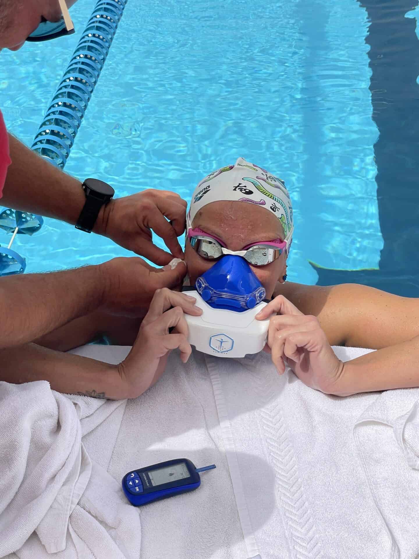 Verena Schott shown using the VO2 master analyzer device at the poolside 