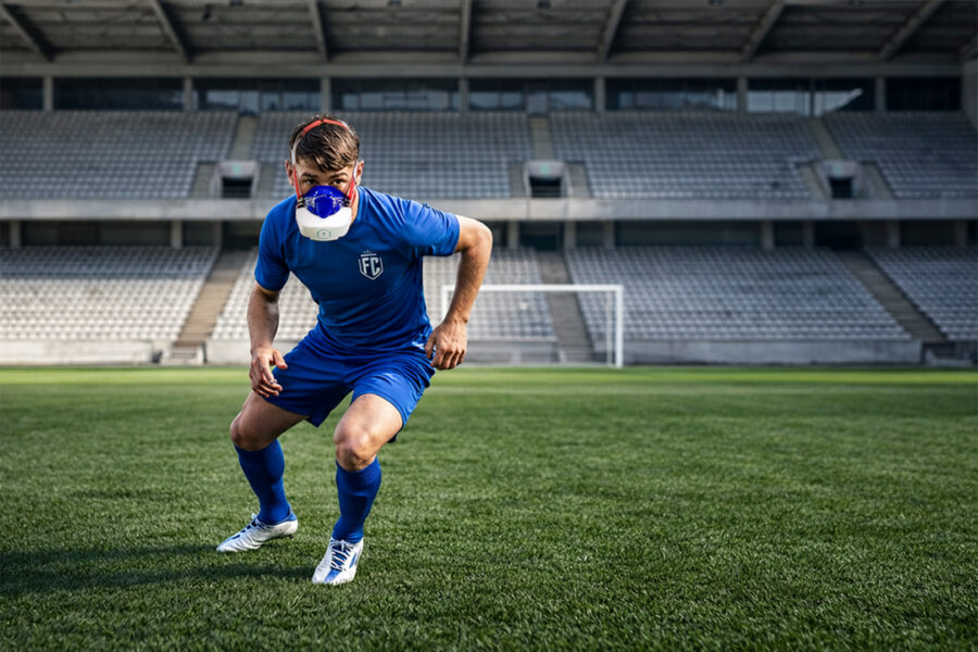Soccer player wearing a portable metabolic testing mask during on field VO2 Max testing to analyze metabolic limiters in soccer performance.