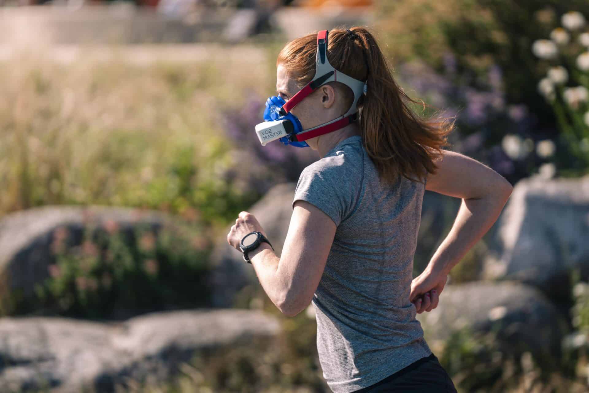 Woman running outdoors, measuring VT zones with the VO2 Master analyzer and mask