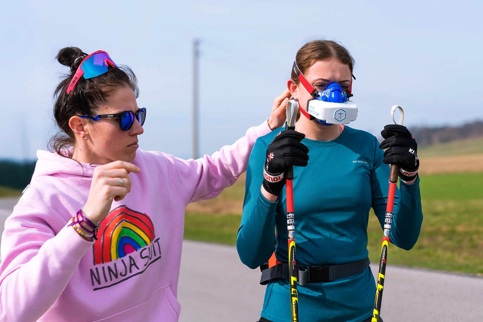 Coach Dr. Eva Piatrikova fitting a female athlete with a portable metabolic analyzer before an outdoor endurance training session.