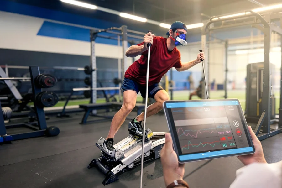 Strength and conditioning athlete wearing a portable VO2 analyzer during indoor metabolic testing to measure aerobic capacity.
