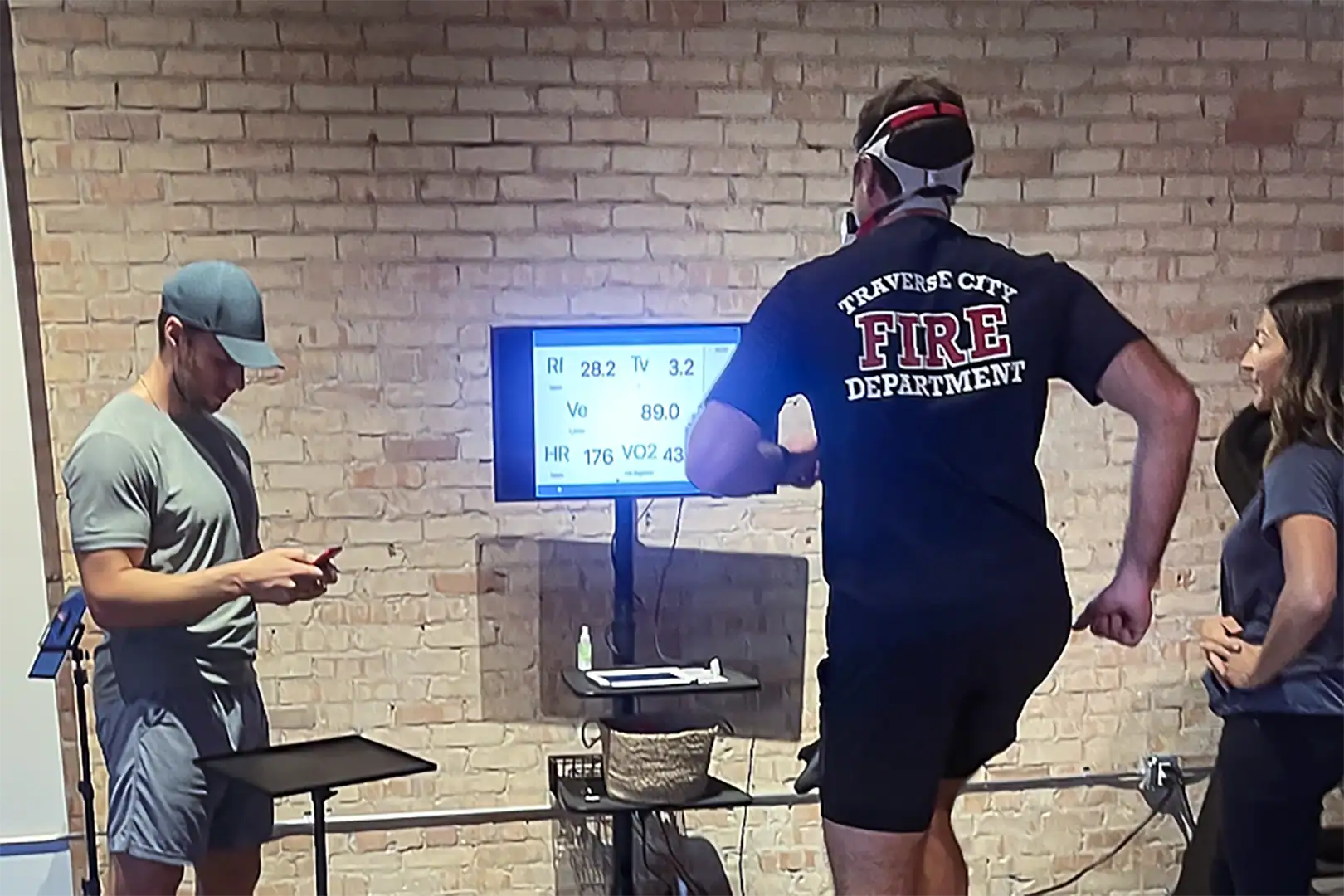 Firefighters completing on-site VO2 testing while a fitness professional monitors metabolic data and heart rate for readiness evaluation.