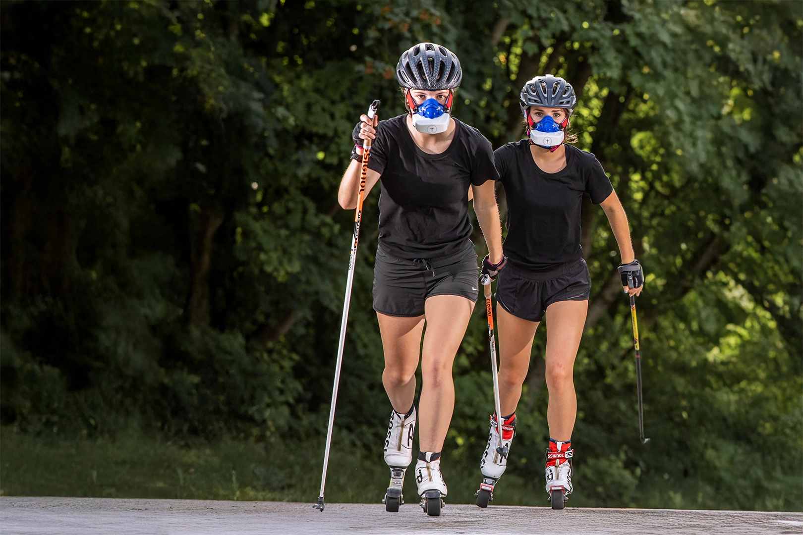 Athletes using portable metabolic testing during outdoor roller ski training to assess aerobic capacity.