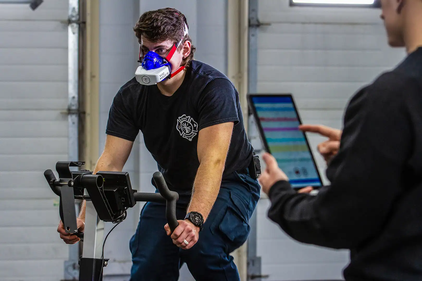 Firefighters completing on-site VO2 testing while a fitness professional monitors metabolic data and heart rate for readiness evaluation.