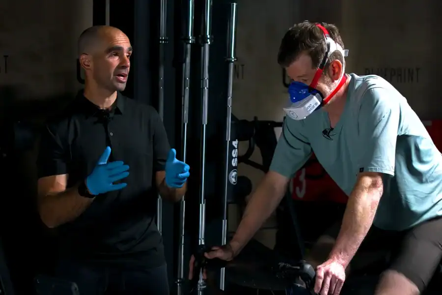 Fitness professional Joel Harwood is coaching an athlete during portable VO2 metabolic testing for personalized training zones