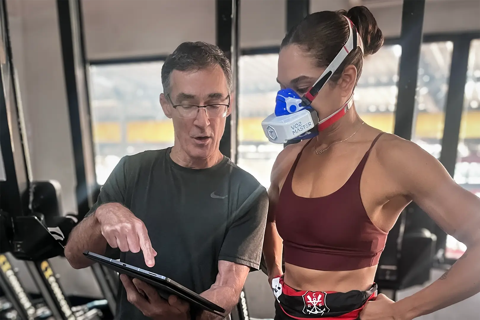 Coach Roger de Moraes reviewing VO2 testing data with an athlete wearing a VO2 Master analyzer during performance testing
