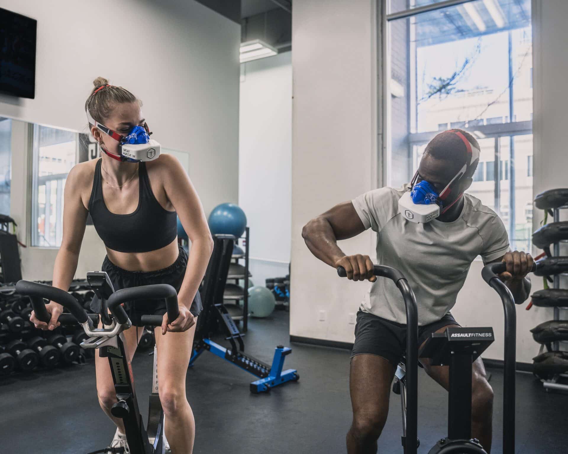 Athletes on indoor elliptical and bike, monitoring VT zones and performance data