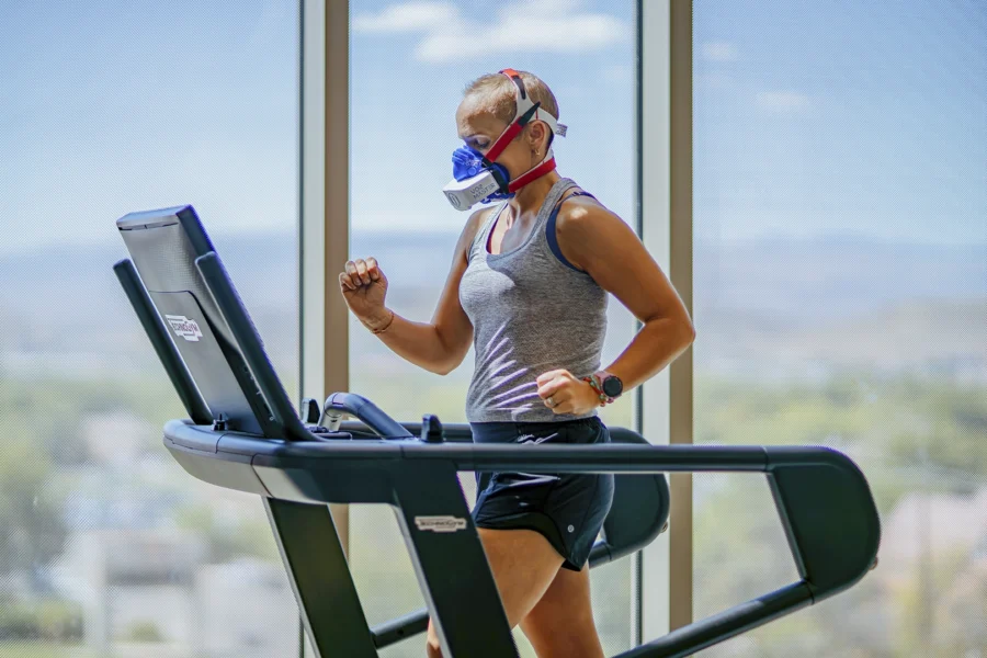 Athlete performing VO2 max testing on a treadmill using a portable metabolic testing device to measure real-time oxygen consumption and energy expenditure.