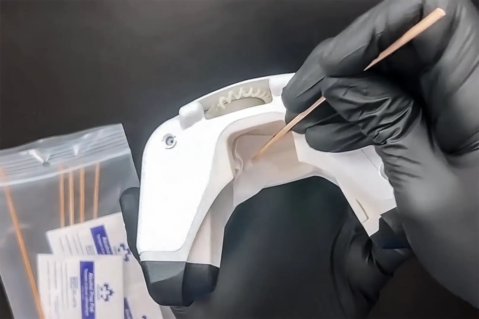 Gloved hands cleaning a VO2 testing mask as part of sanitation between athlete metabolic assessments.