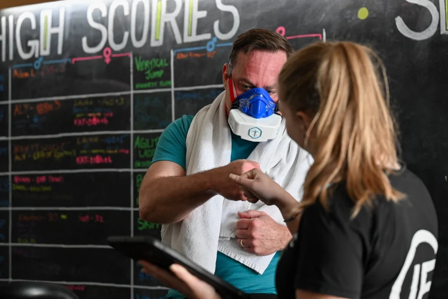 Personal trainer conducting VO2 testing at Innovative Fitness for client retention using portable metabolic testing equipment in a gym setting