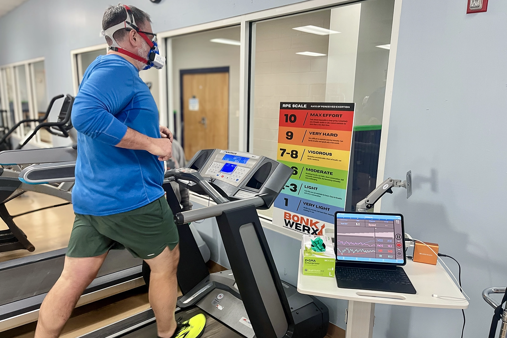 Client performing VO2 max testing on a treadmill using a portable metabolic analyzer during executive health assessment.