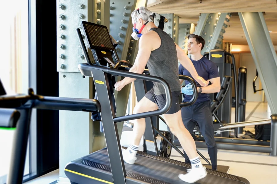 Client performing VO2 max testing on a treadmill using a portable metabolic analyzer during executive health assessment.